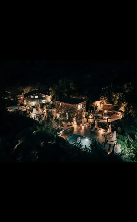 Αεροφωτογραφία του φωτισμένου πέτρινου retreat τη νύχτα στα Περιβόλια Ινναχωρίου